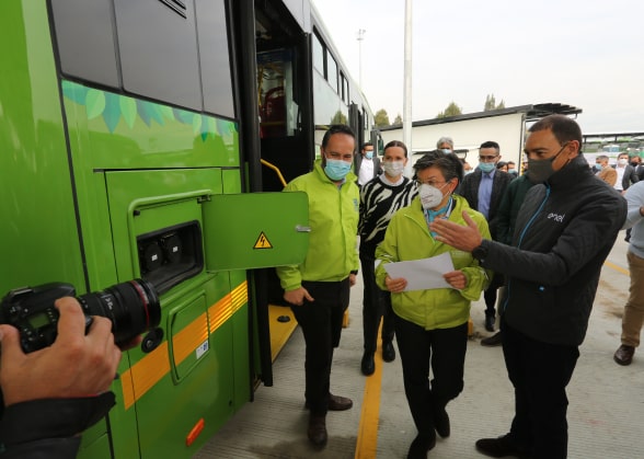 People near the charging socket of an electric bus